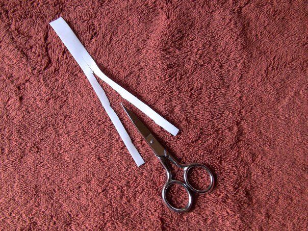 Scissors and adhesive tape cut into half lengthwise